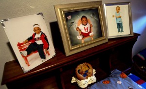 Photographs of Titches Lindley sitting above his bed at the home of his father, William Wade, in Dallas. Photograph by Melanie Buford for The Dallas Morning News